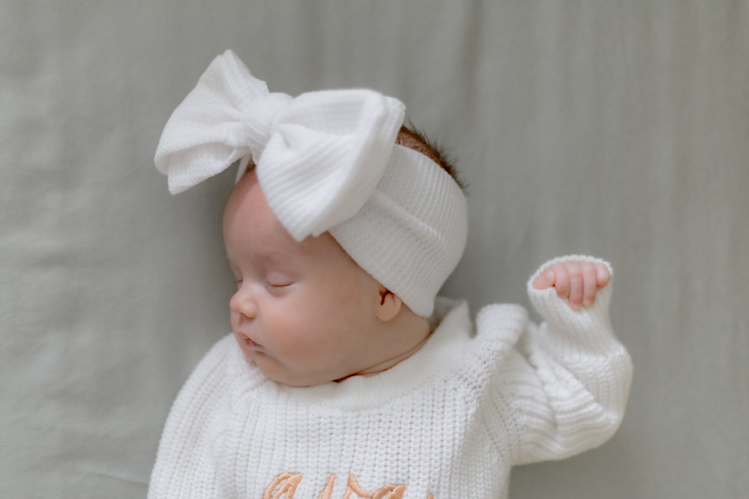 baby girl sleeping in crib with bow on her head natural light in louisville kentucky