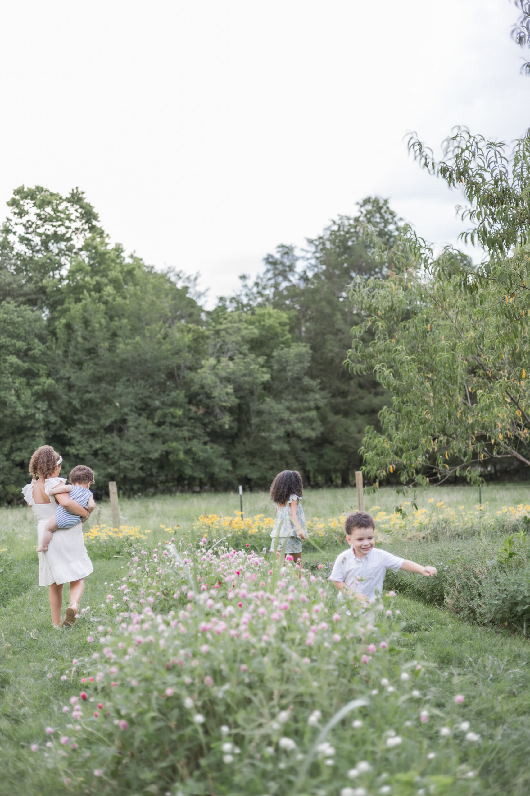 young kids walking through flower field running and having fun
