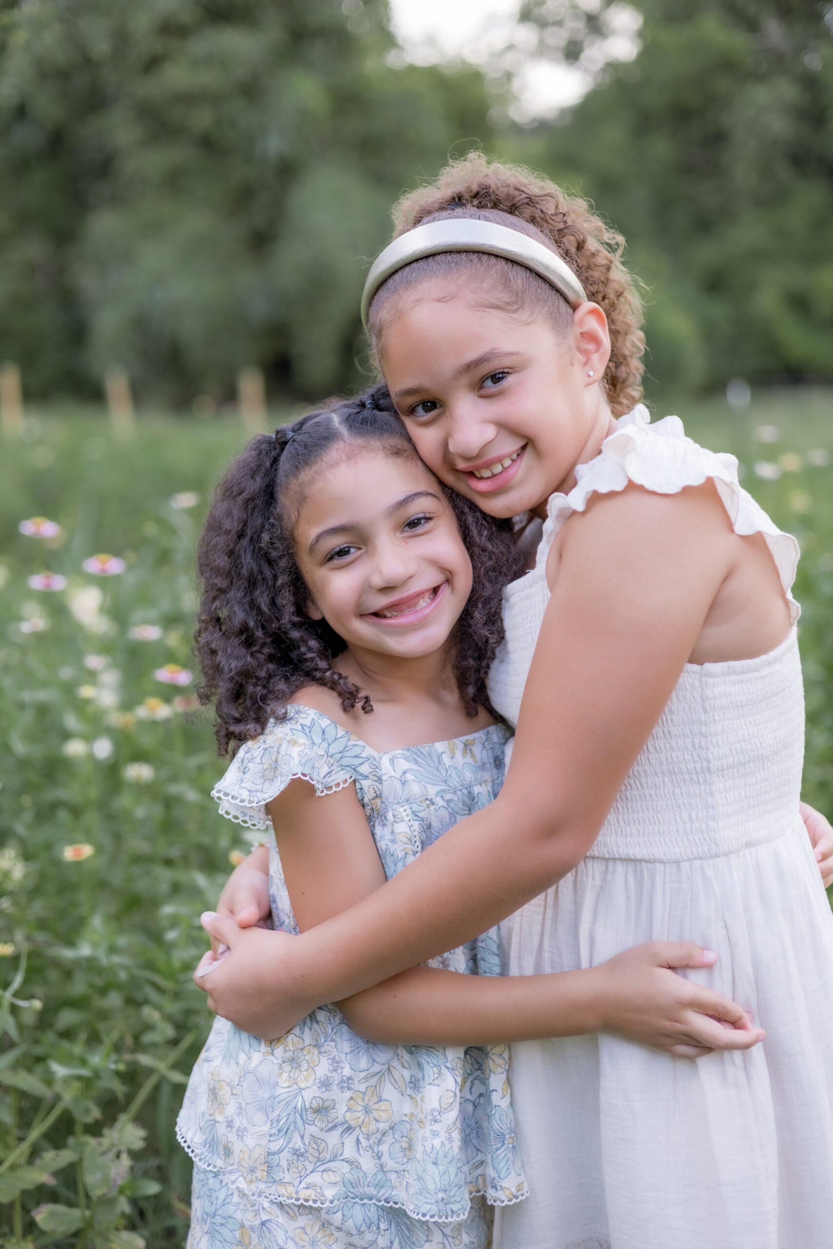 two sisters hugging in flower field